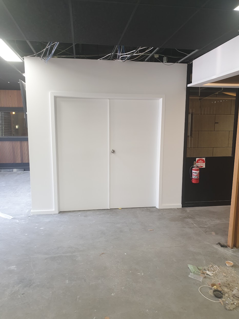 Painted commercial doors, door frame and wall in a completed fit-out