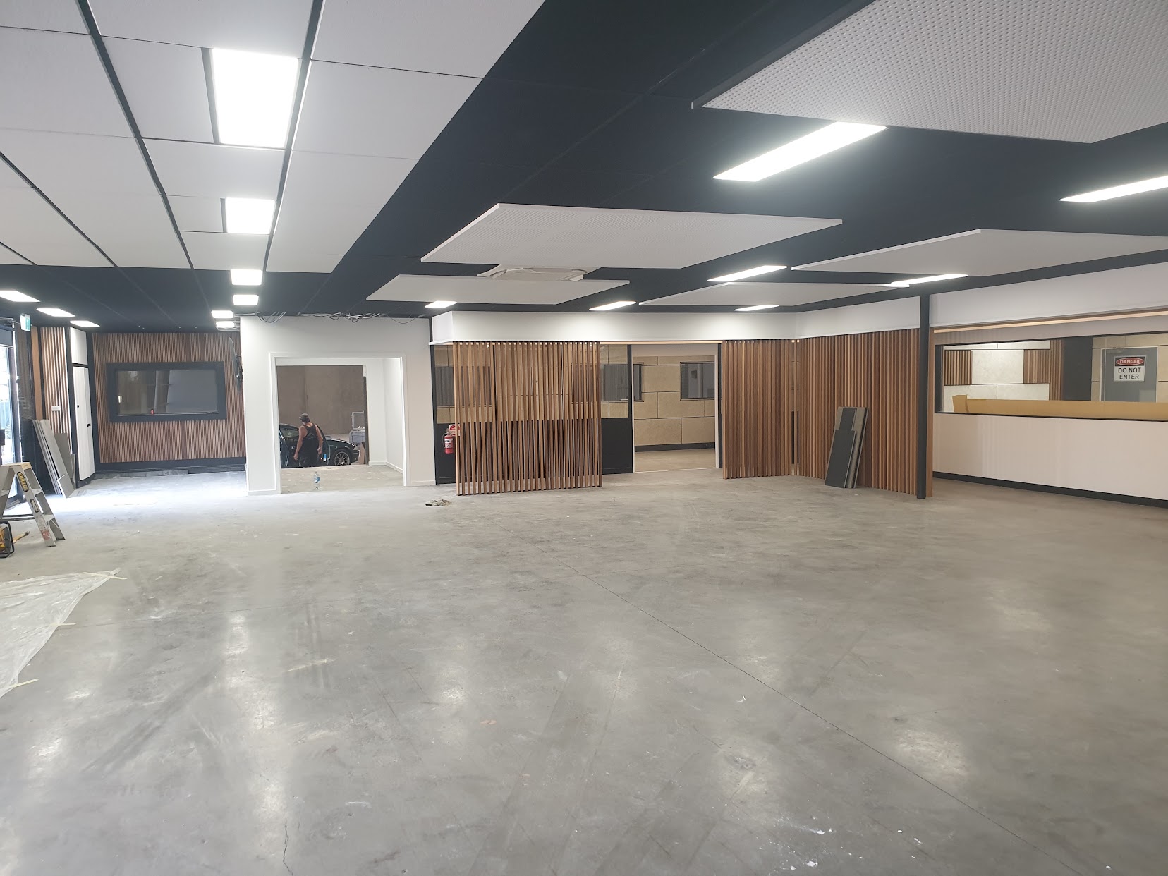 Large open commercial interior with painted walls and a two-tone ceiling grid